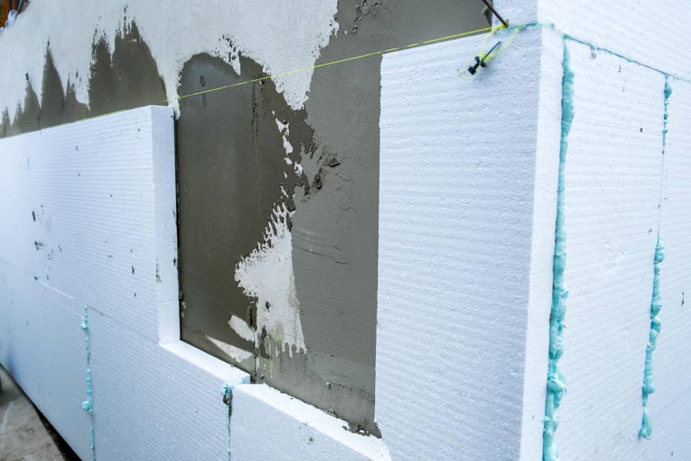 Arbeiter bringt eine Wärmedämmung an der Fassade an