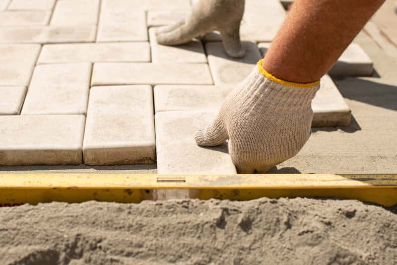 Gartenweg wird mit Pflastersteinen verlegt